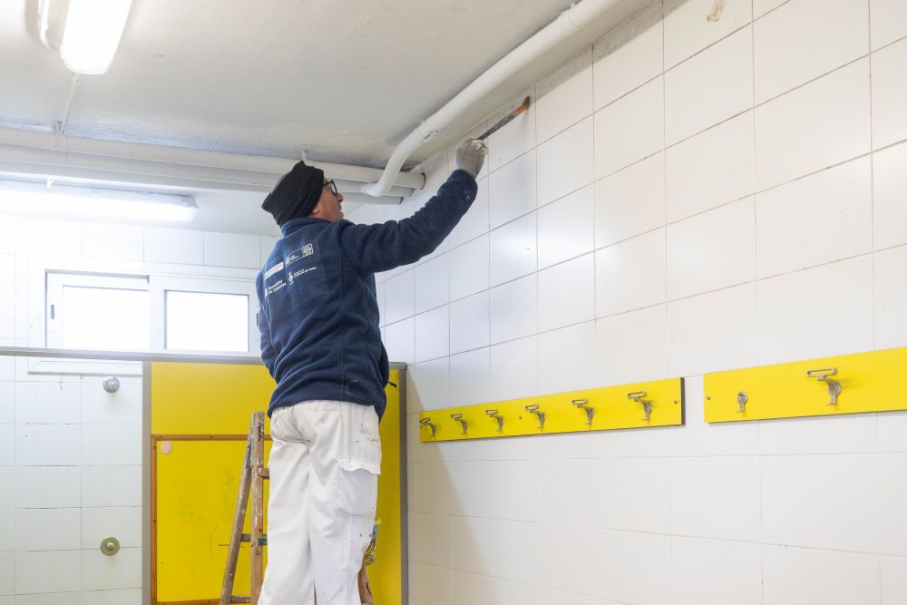 Pintor treballant en un pla d'ocupació a la zona esportiva de La Bòbila