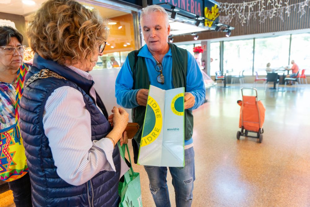 Educador ambiental d'Ecovidrio informant i repartint bosses per fomentar el reciclatge de vidre